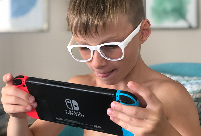 Child with glasses playing handheld games