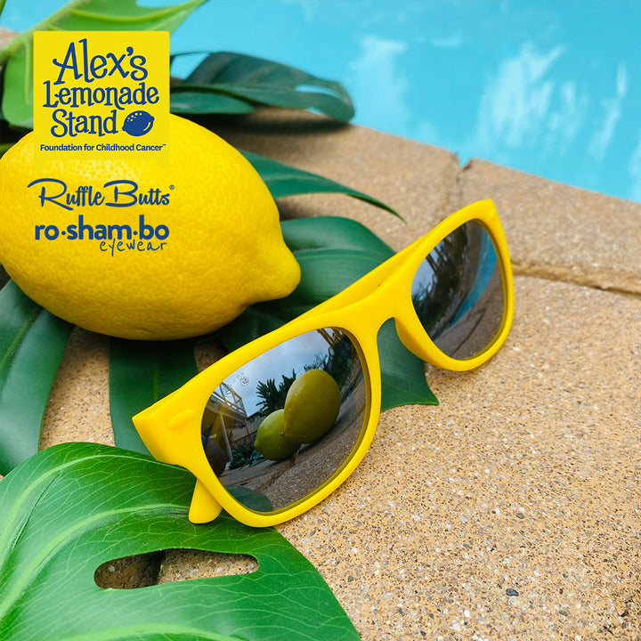 Traje de baño de sirsaca para niño pequeño de RuffleButts con gafas de sol amarillas Roshambo