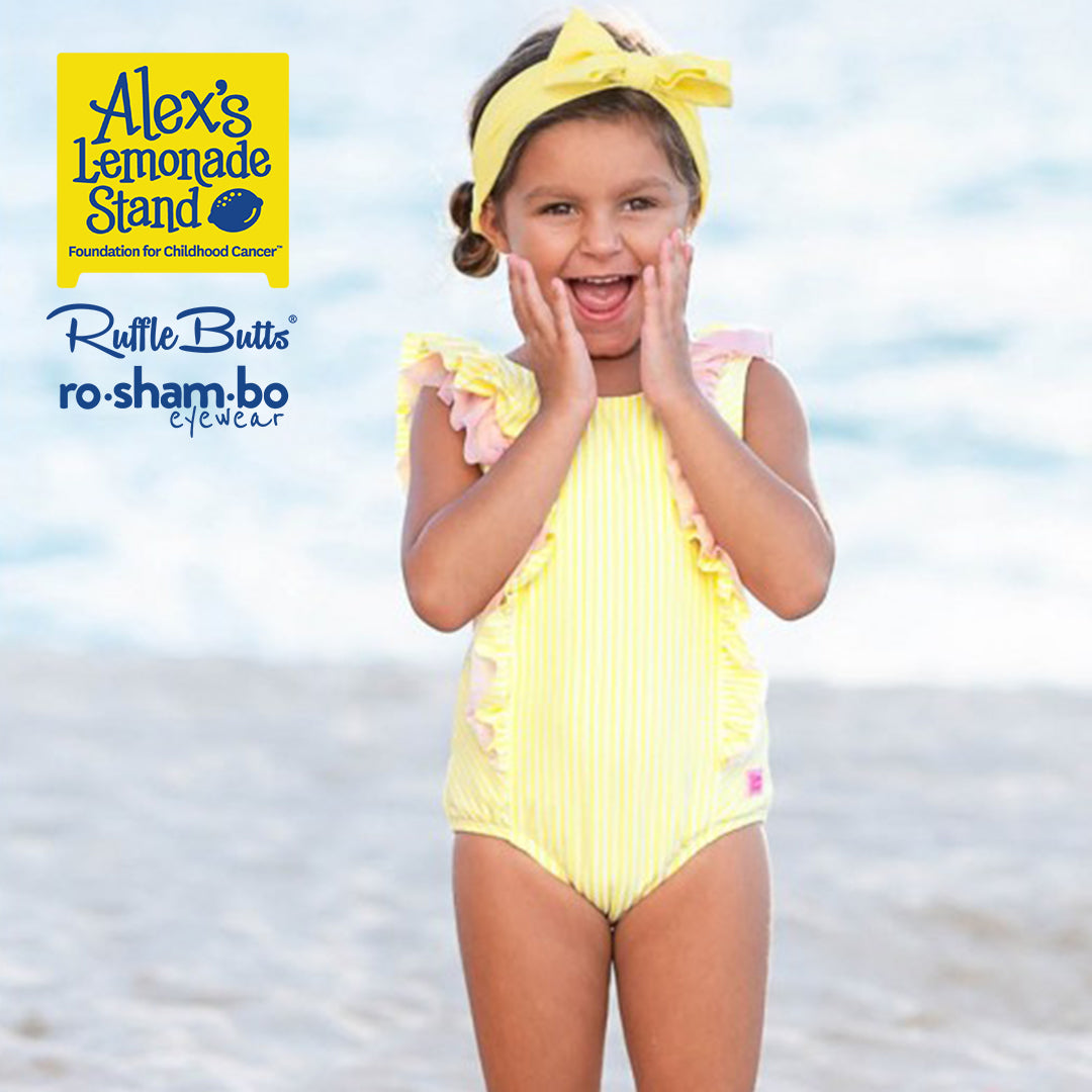 Traje de baño de sirsaca para niño pequeño de RuffleButts con gafas de sol amarillas Roshambo